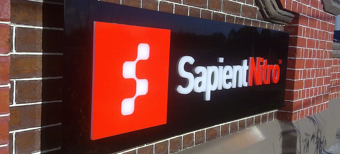 Illuminated Sapient Nitro sign on a brick wall