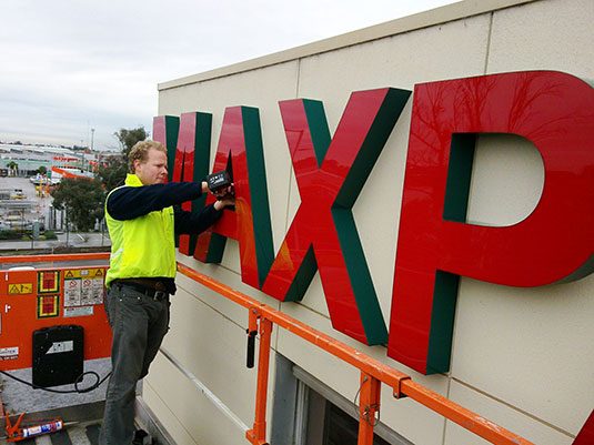 Our director on a scissor lift fixing the Maxpak letters
