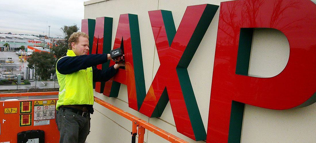 Fixing the fabricated Maxpak letters from a scissor lift