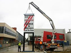 A crane lifting a pylon sign into place